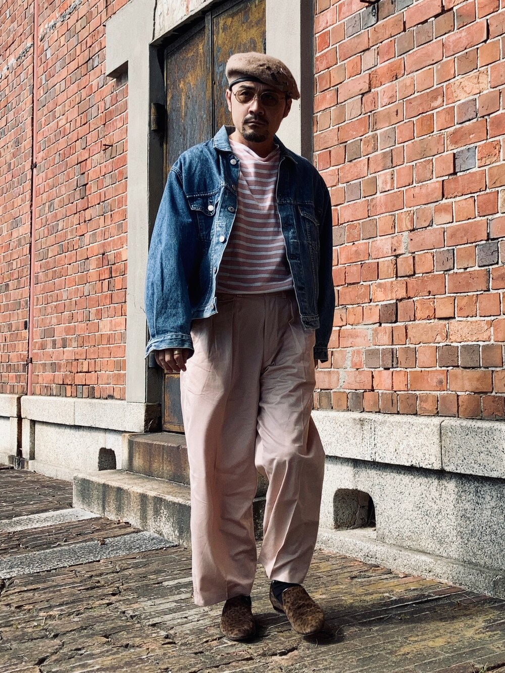 ピンク系のTシャツ/カットソー、ブルー系のデニムジャケット、ピンク系のスラックスを着用したメンズの秋コーディネートの2枚目の写真