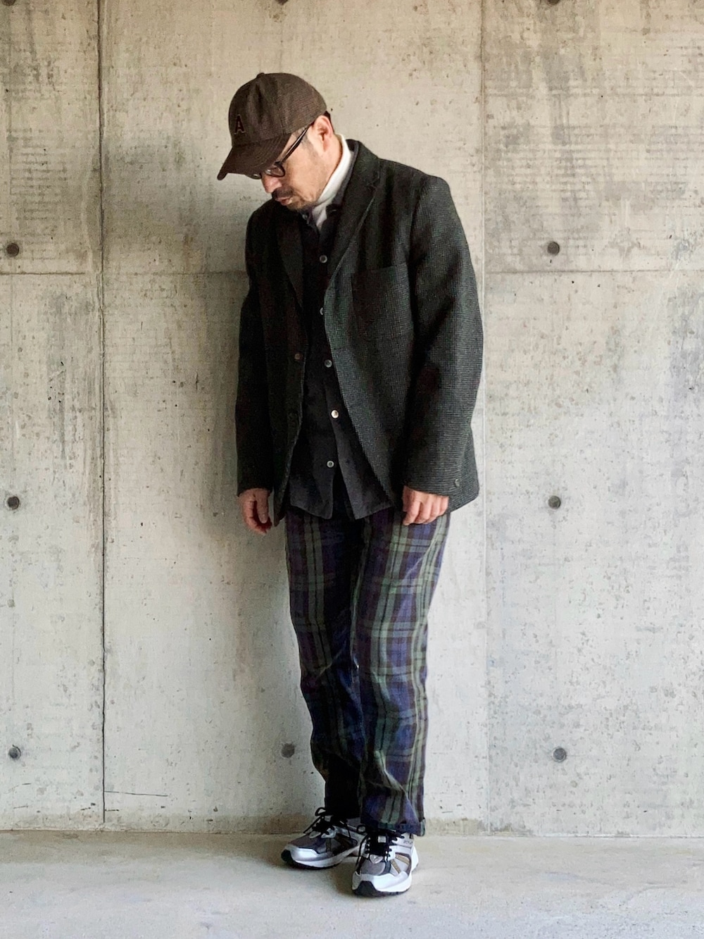 グレー系のテーラードジャケット、グリーン系のチノパンツ、ブラック系のスニーカーを着用したメンズの秋コーディネートの3枚目の写真