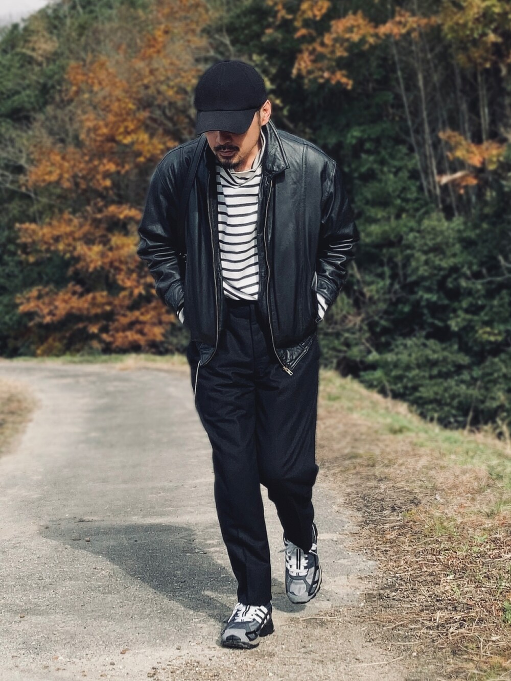 ブラック系のTシャツ/カットソー、ブラック系のブルゾン、ブラック系のスラックスを着用したメンズの冬コーディネートの3枚目の写真