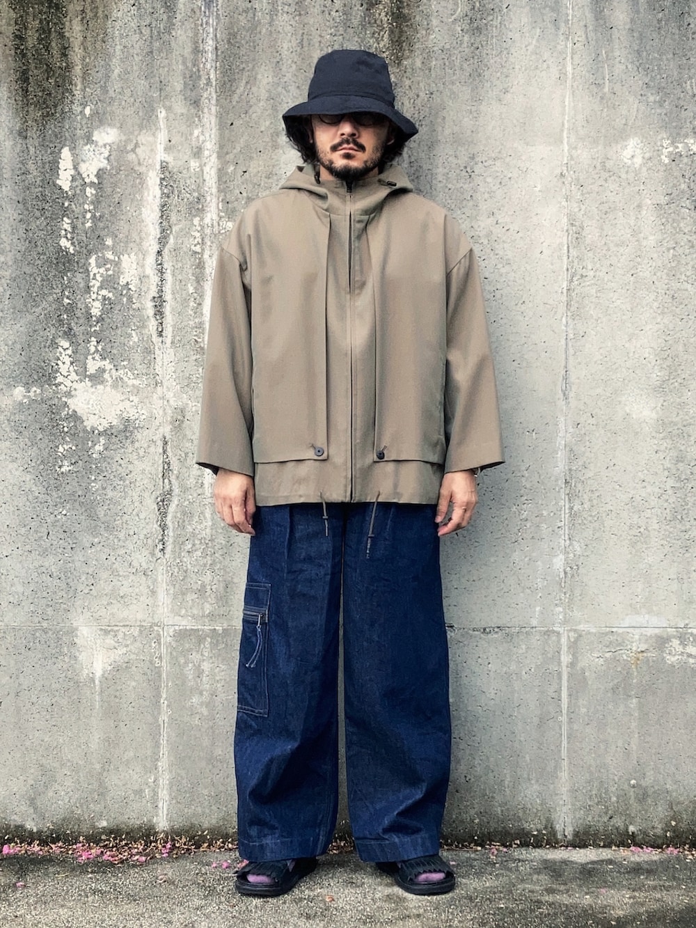 ベージュ系のブルゾン、ブルー系のデニムパンツ、ブラック系のサンダルを着用したメンズの秋コーディネートの3枚目の写真