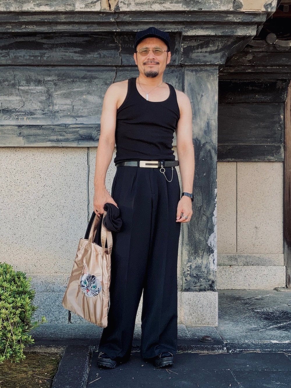 ブラック系のタンクトップ、ブラック系のテーラードジャケット、ブラック系のスラックスを着用したメンズの秋コーディネートの4枚目の写真