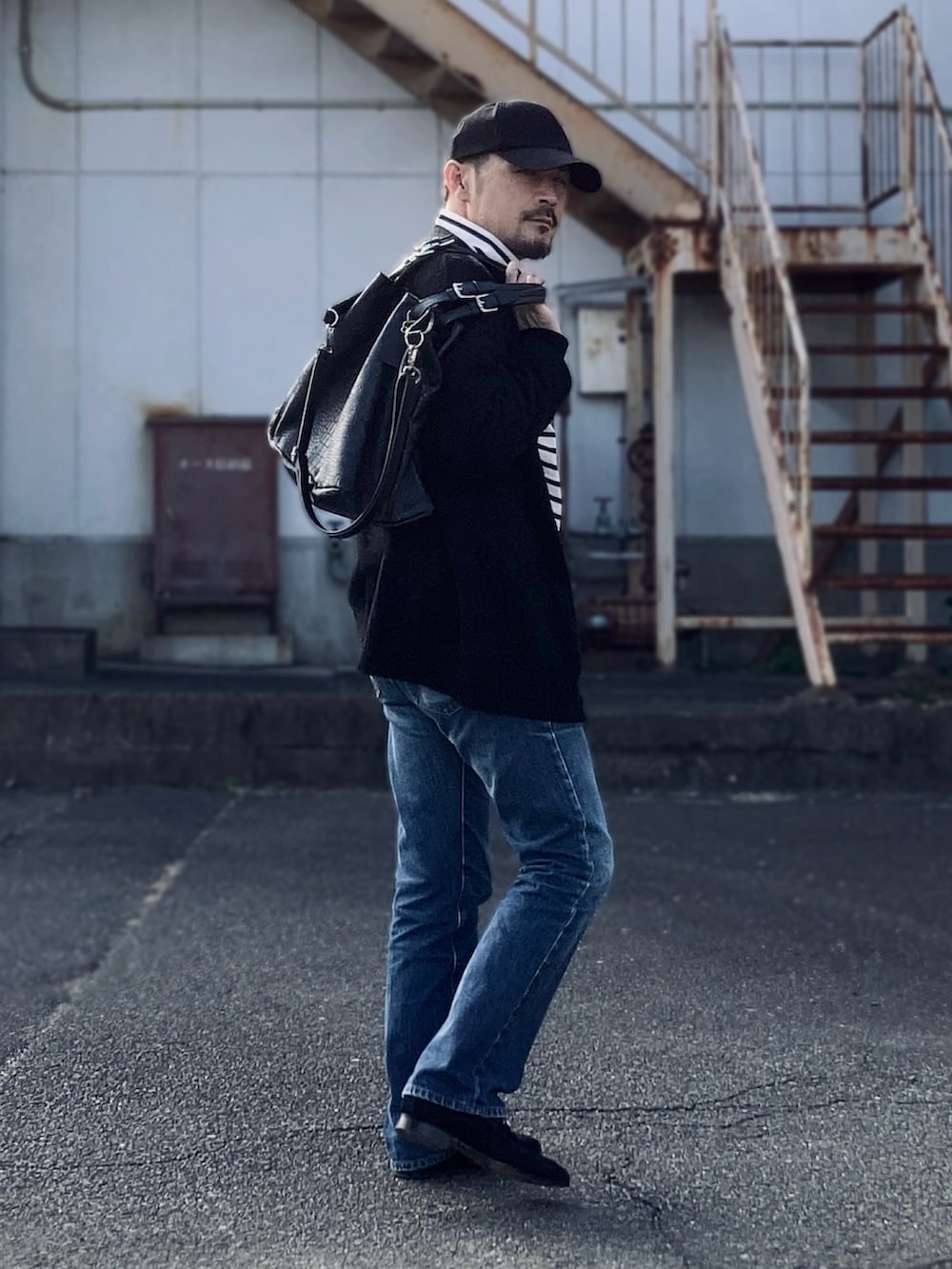 ブラック系のTシャツ/カットソー、ブラック系のカーディガン/ボレロ、ブルー系のデニムパンツを着用したメンズの冬コーディネートの3枚目の写真