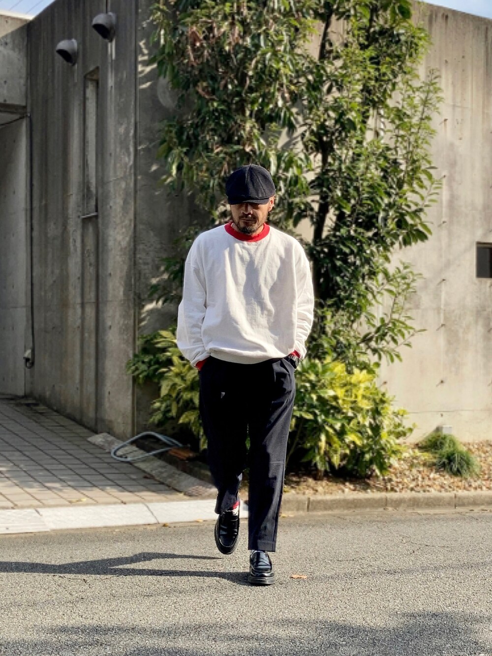 ホワイト系のスウェット、ブルー系のスラックス、ブラック系のローファーを着用したメンズの秋コーディネートの2枚目の写真