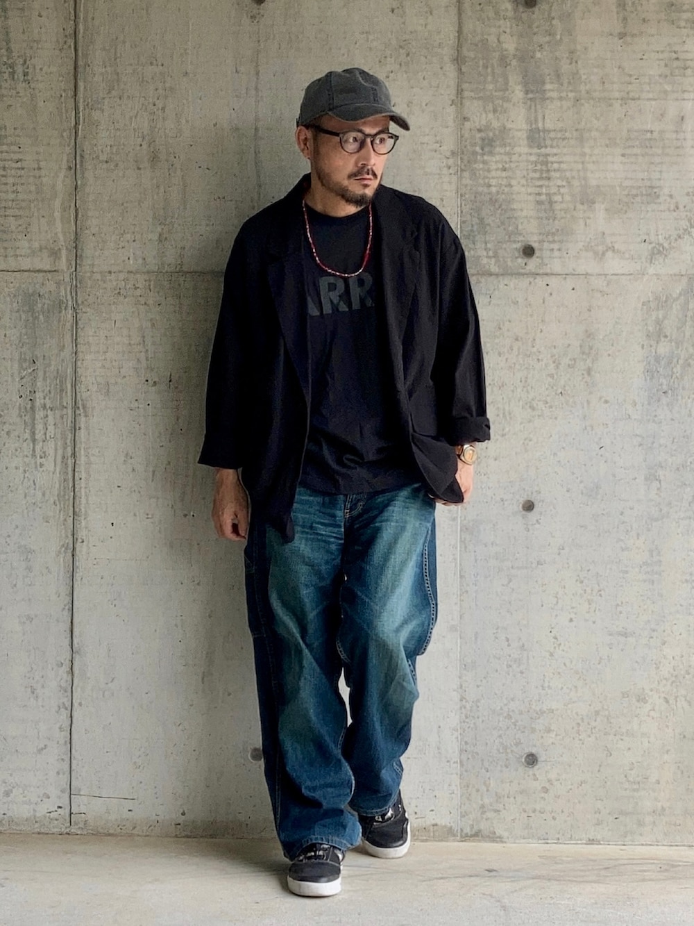 ブラック系のTシャツ/カットソー、ブラック系のテーラードジャケット、ブルー系のデニムパンツを着用したメンズの夏コーディネートの2枚目の写真