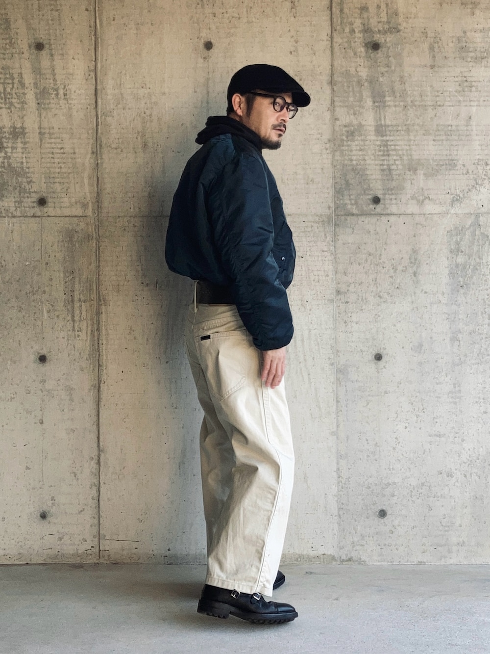 ホワイト系のデニムパンツ、ブラック系のパーカー、ブルー系のMA-1を着用したメンズの冬コーディネートの2枚目の写真