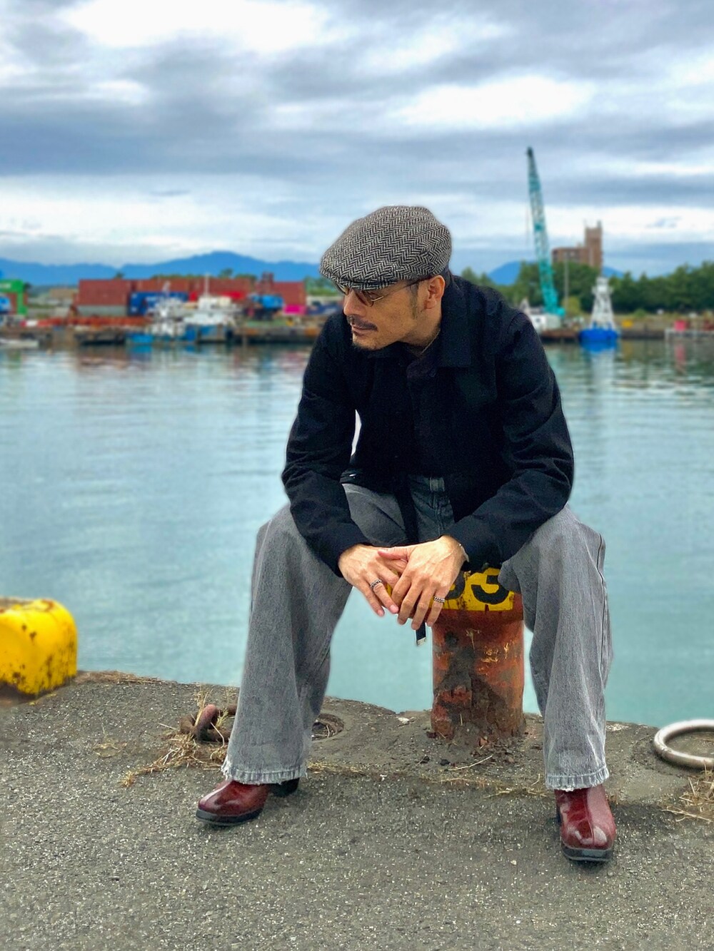 ブラウン系のTシャツ/カットソー、ブラック系のデニムジャケット、グレー系のデニムパンツを着用したメンズの秋コーディネートの4枚目の写真