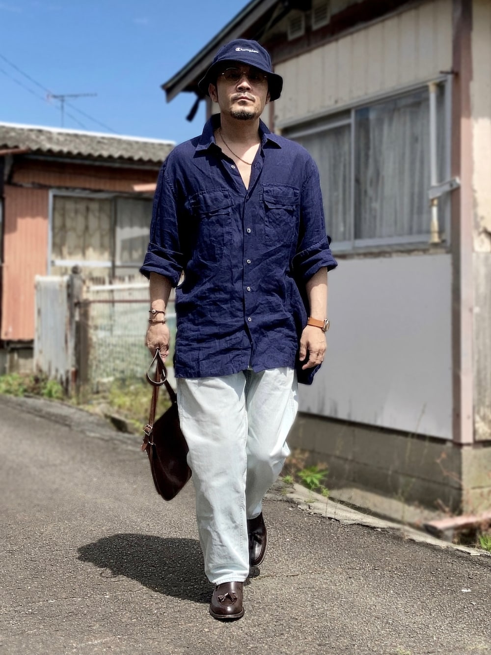 ブルー系のシャツ/ブラウス、ブルー系のデニムパンツ、ブラウン系のローファーを着用したメンズの夏コーディネートの3枚目の写真