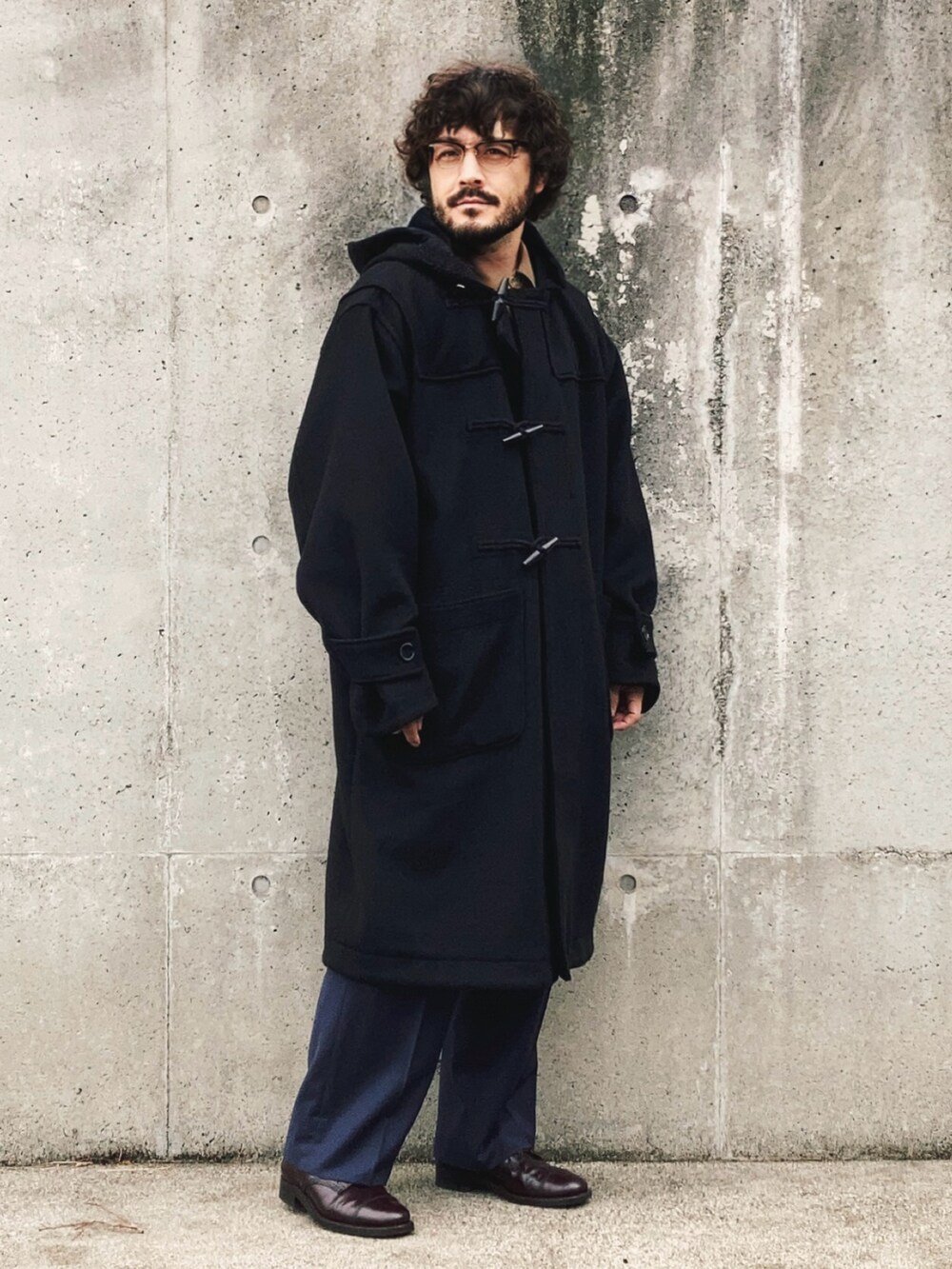 ブラック系のダッフルコート、ベージュ系のセットアップ、ブルー系のスラックスを着用したメンズの秋コーディネートの4枚目の写真