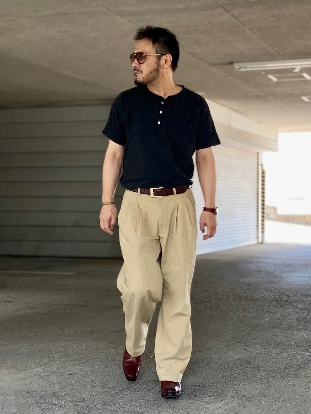 ブラック系のTシャツ/カットソー、ベージュ系のスラックス、レッド系のブーツを着用したメンズの秋コーディネートの4枚目の写真