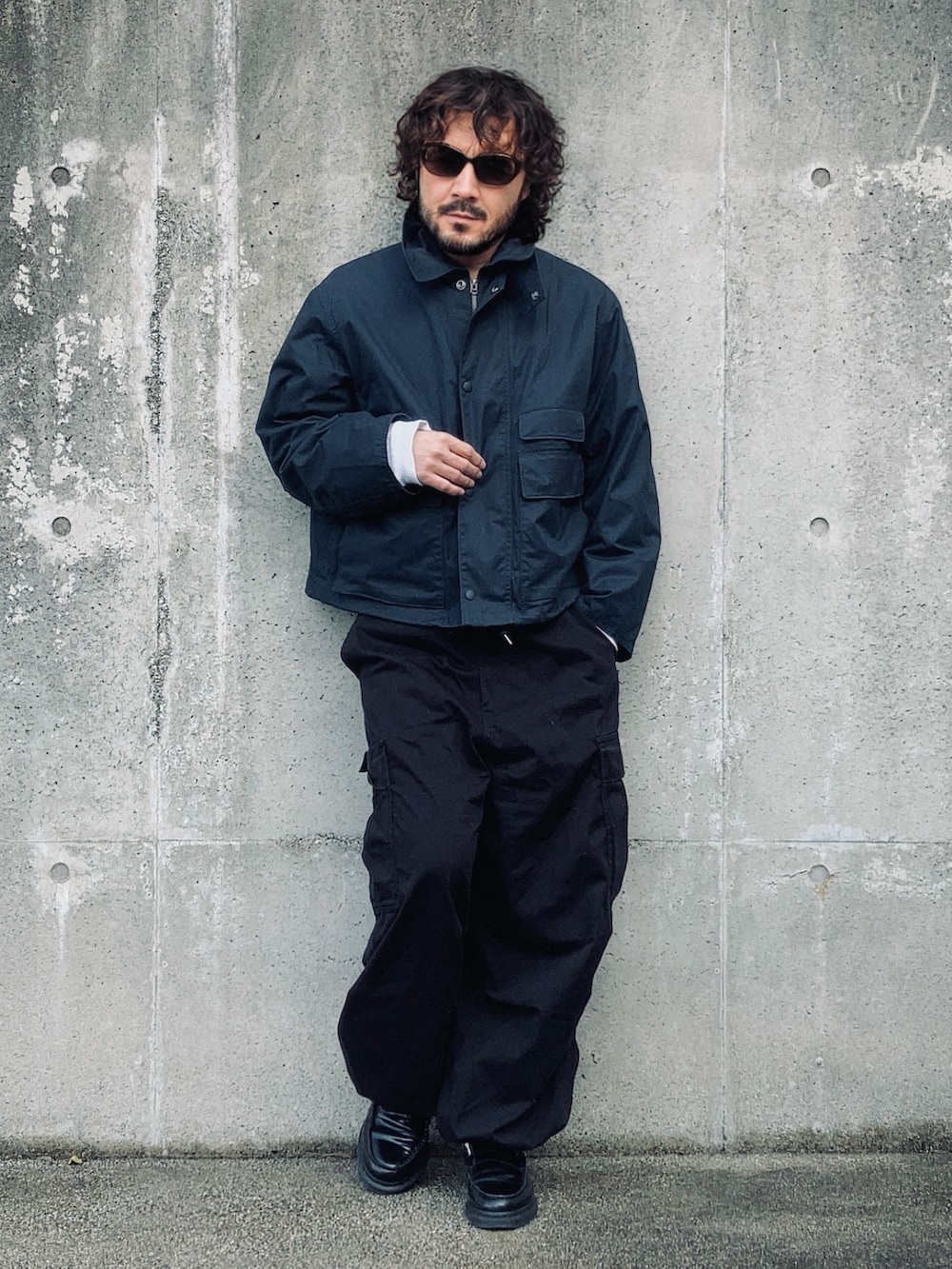 ブルー系のマウンテンパーカー、ホワイト系のTシャツ/カットソー、ブラック系のカーゴパンツを着用したメンズの冬コーディネートの2枚目の写真