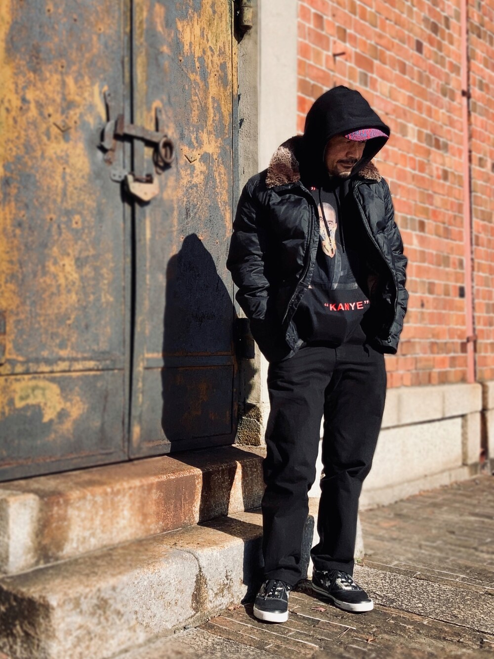 ブラック系のパーカー、ブラック系のダウンジャケット/コート、ブラック系のパンツを着用したメンズの冬コーディネートの4枚目の写真