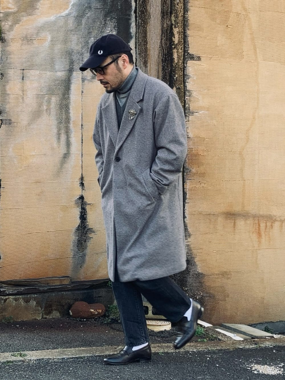 グレー系のニット/セーター、グレー系のニット/セーター、グレー系のチェスターコートを着用したメンズの冬コーディネートの4枚目の写真