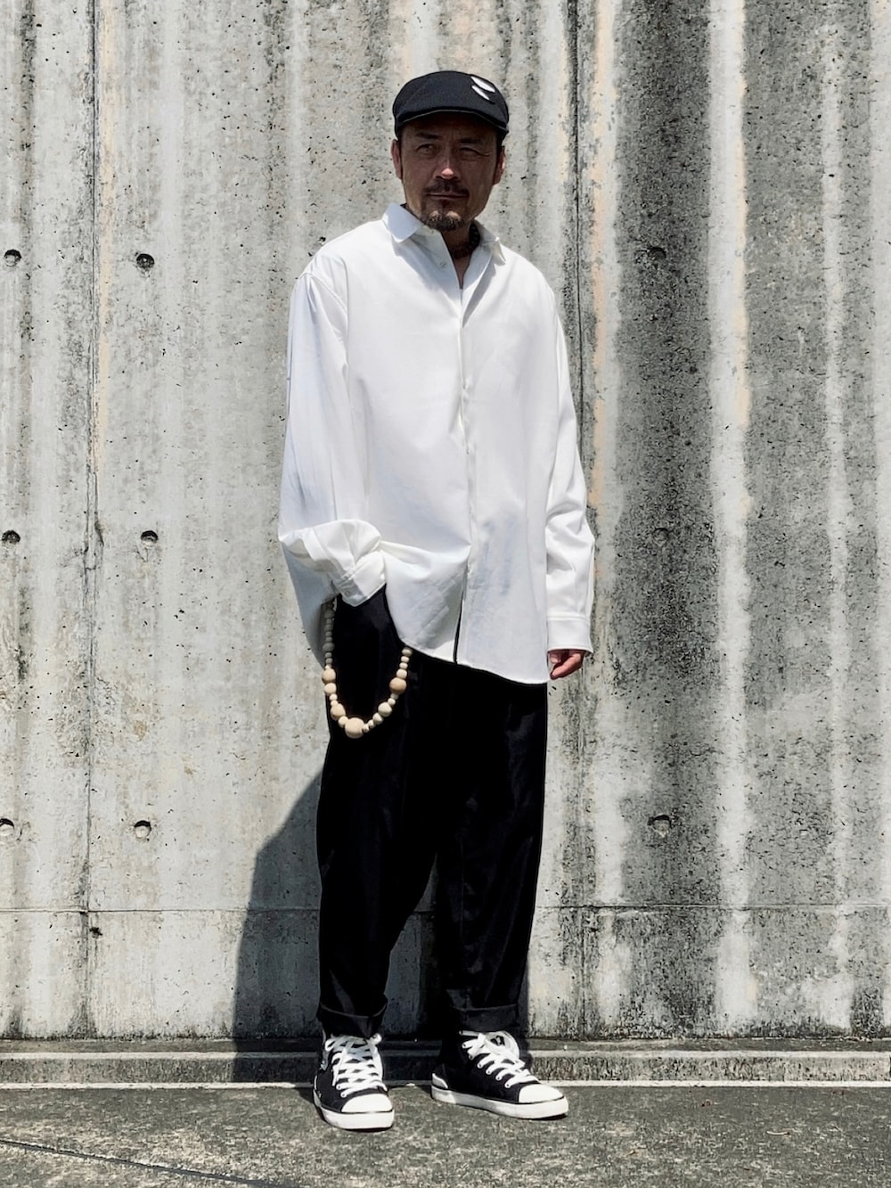 ホワイト系のシャツ/ブラウス、ブラック系のスラックス、ブラック系のスニーカーを着用したメンズの春コーディネートの5枚目の写真