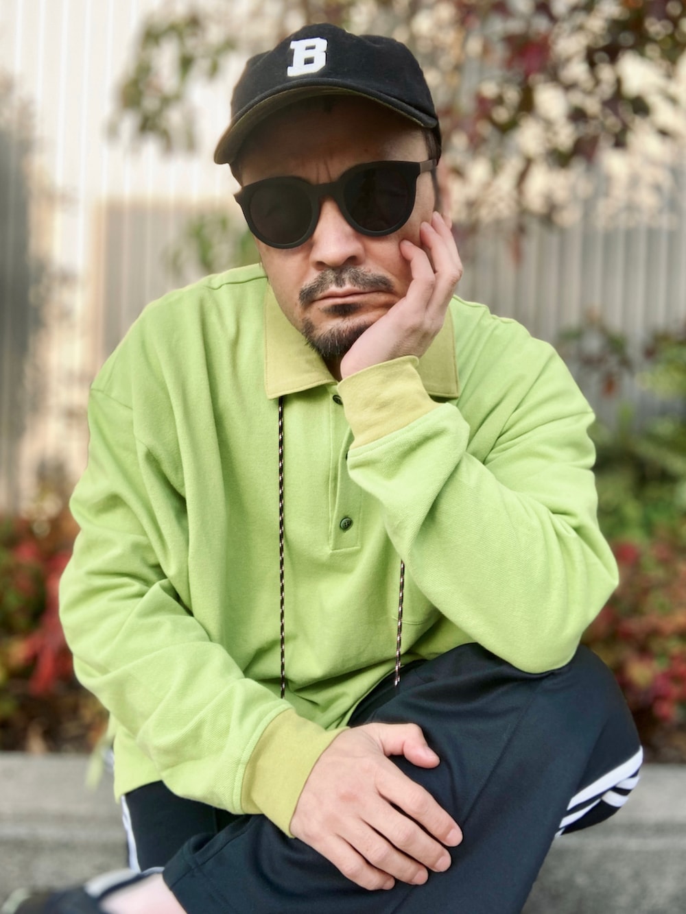 グリーン系のポロシャツ、ブラック系のスウェットパンツ、ブラック系のスニーカーを着用したメンズの春コーディネートの5枚目の写真