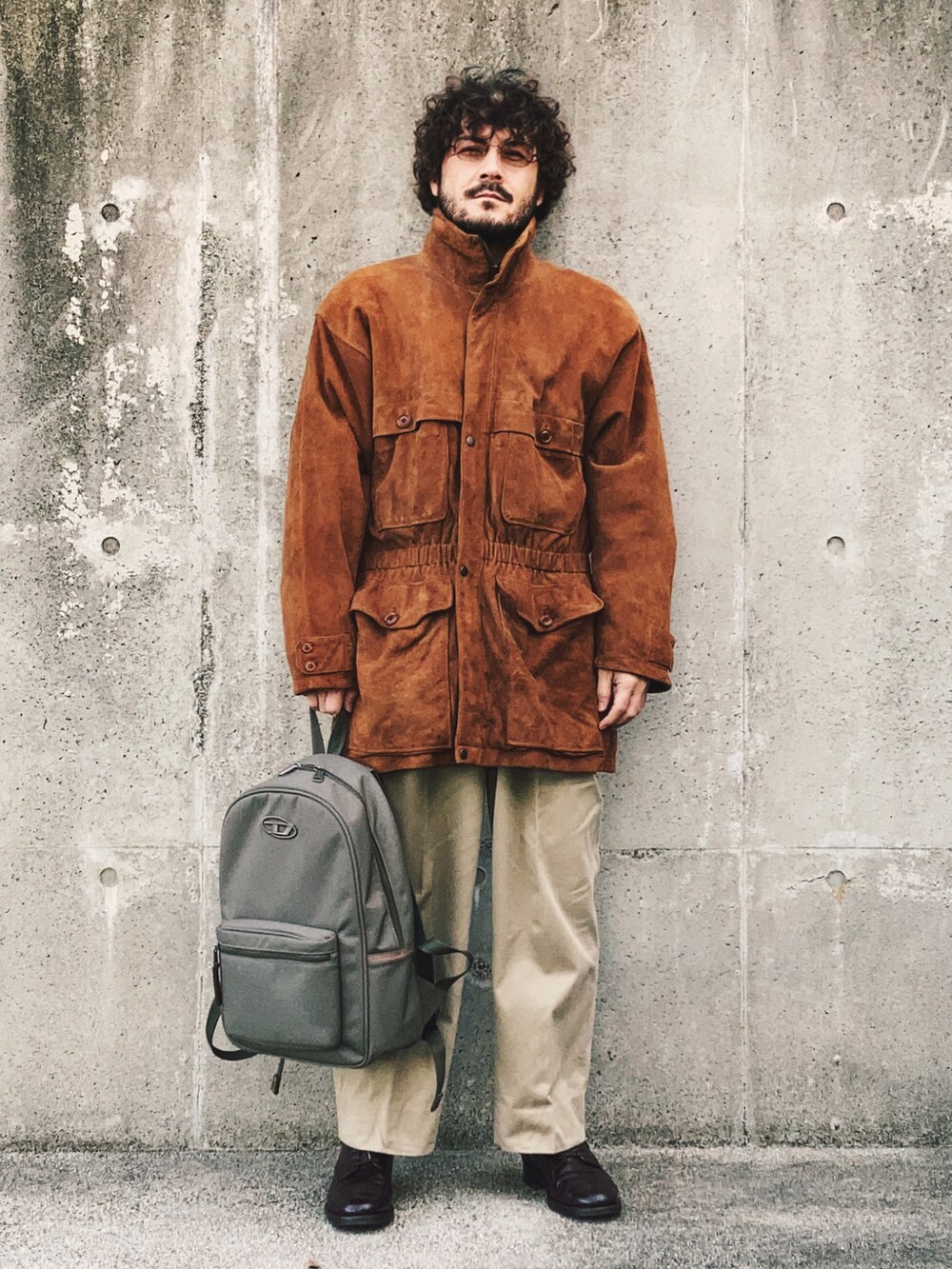 ブラウン系のその他アウター、ベージュ系のチノパンツ、レッド系のドレスシューズを着用したメンズの冬コーディネートの2枚目の写真