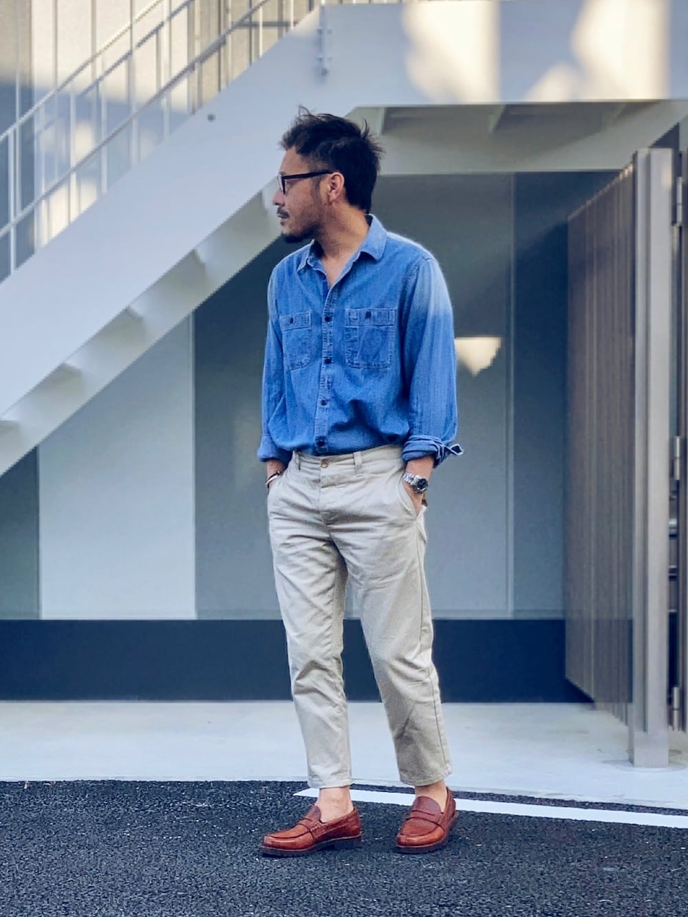 ブルー系のシャツ/ブラウス、ベージュ系のチノパンツ、ブラウン系のローファーを着用したメンズの春コーディネートの2枚目の写真