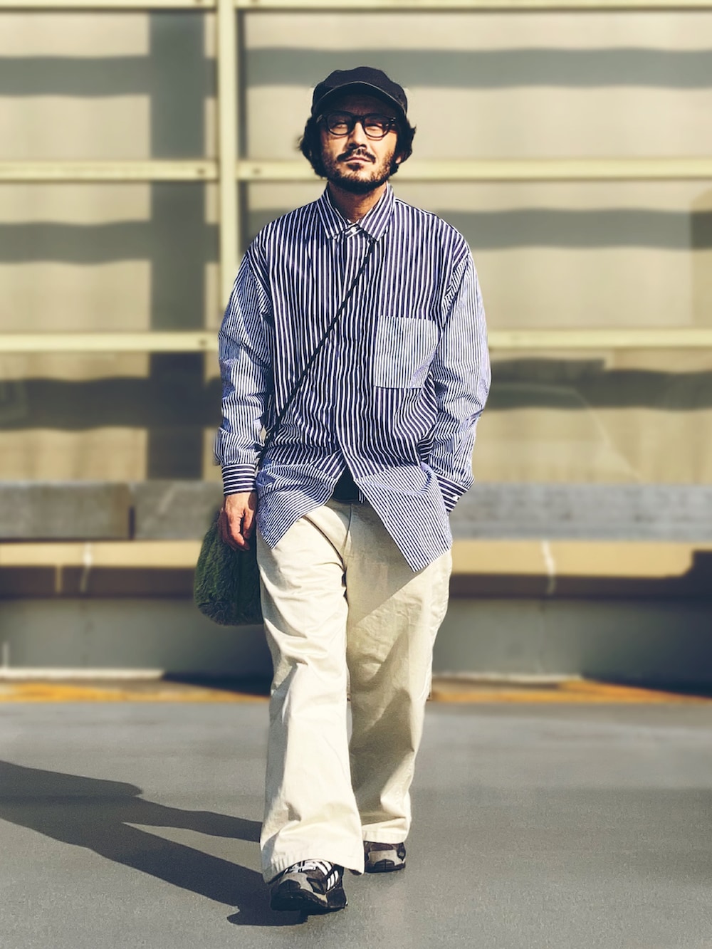 ホワイト系のデニムパンツ、ブルー系のシャツ/ブラウス、ブラック系のスニーカーを着用したメンズの春コーディネートの2枚目の写真