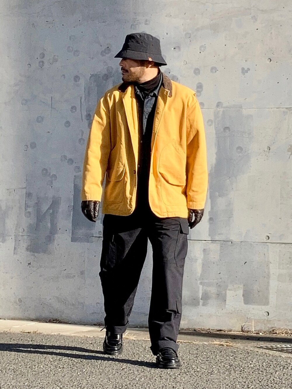 ブラック系のTシャツ/カットソー、ブルー系のデニムジャケット、イエロー系のカバーオールを着用したメンズの冬コーディネートの3枚目の写真