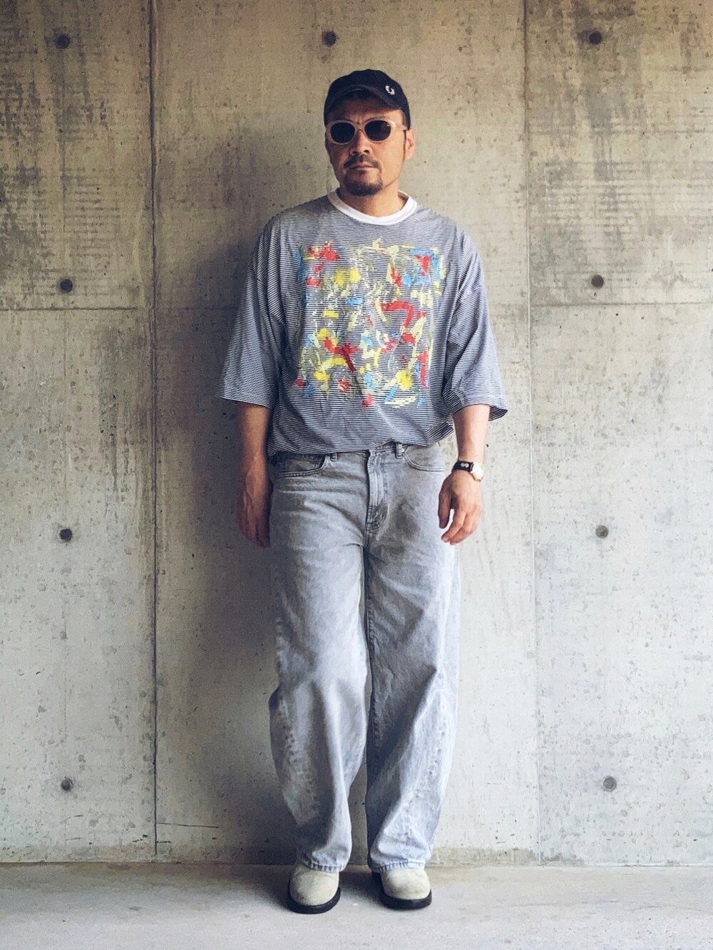 グレー系のデニムパンツ、ホワイト系のTシャツ/カットソー、ベージュ系のブーツを着用したメンズの夏コーディネートの3枚目の写真