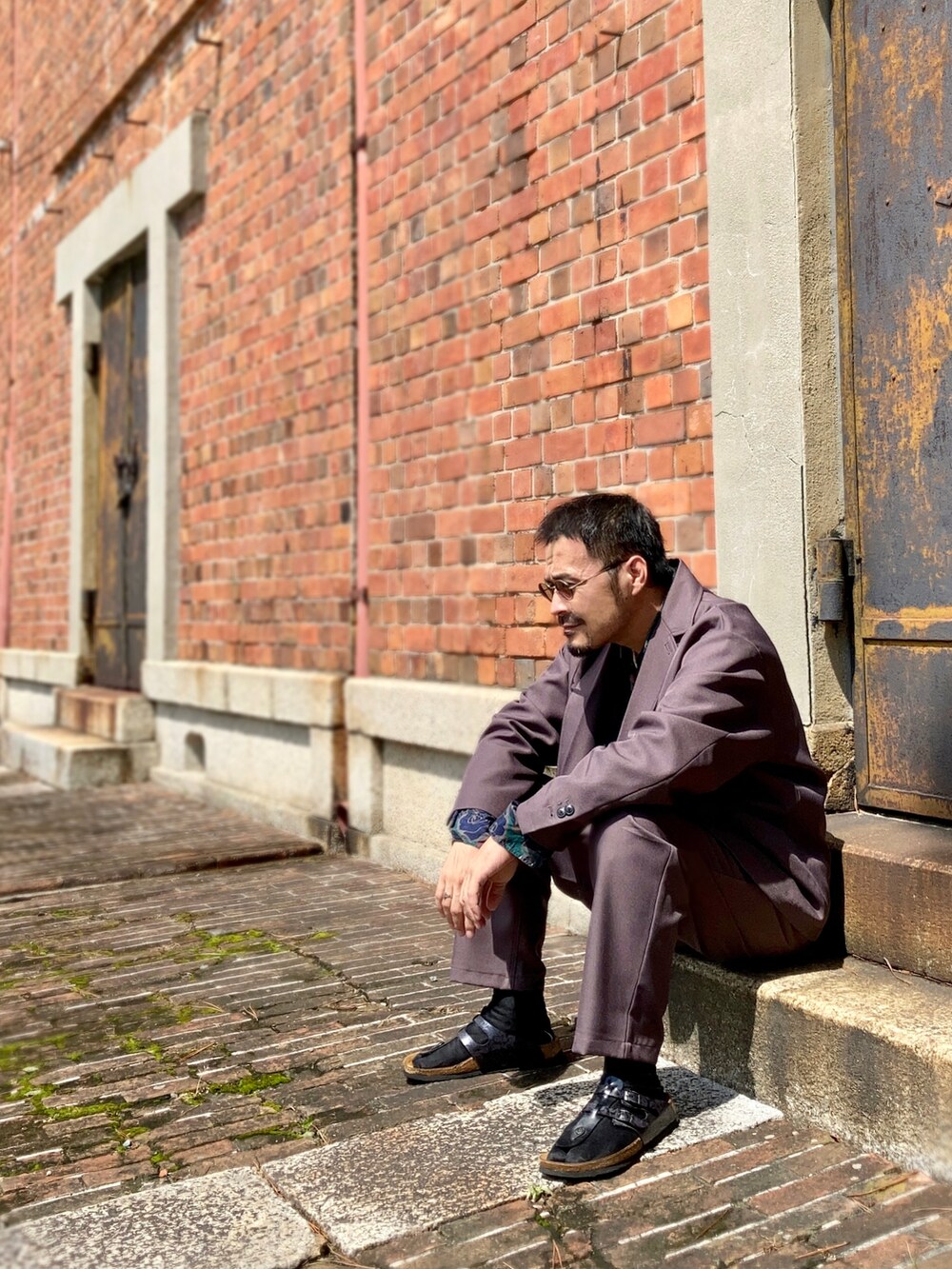 グリーン系のシャツ/ブラウス、グレー系のセットアップ、ブラック系のサンダルを着用したメンズの秋コーディネートの3枚目の写真