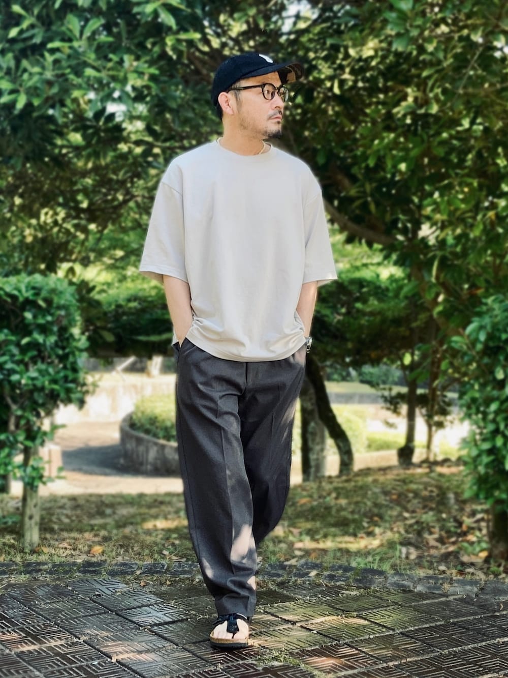 グレー系のTシャツ/カットソー、ブルー系のその他パンツ、ブラック系のサンダルを着用したメンズの夏コーディネートの2枚目の写真