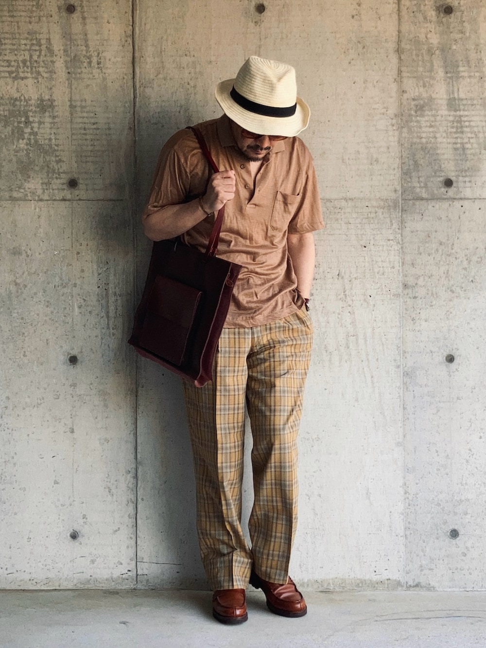 ブラウン系のローファー、ブラウン系のポロシャツ、イエロー系のスラックスを着用したメンズの春コーディネートの2枚目の写真