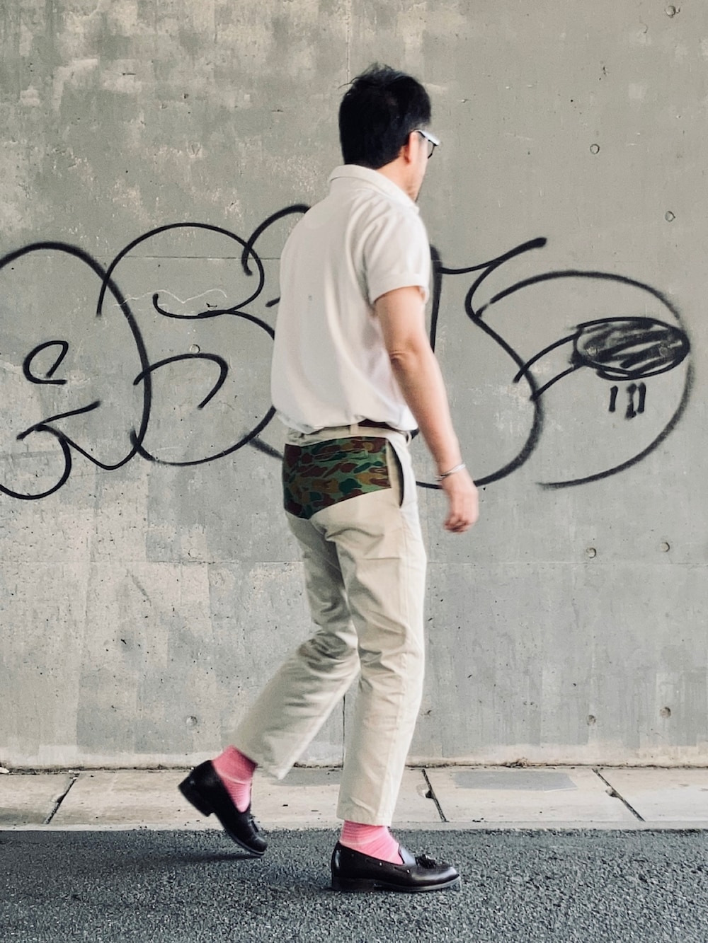 ホワイト系のポロシャツ、ベージュ系のチノパンツ、ブラウン系のローファーを着用したメンズの春コーディネートの3枚目の写真