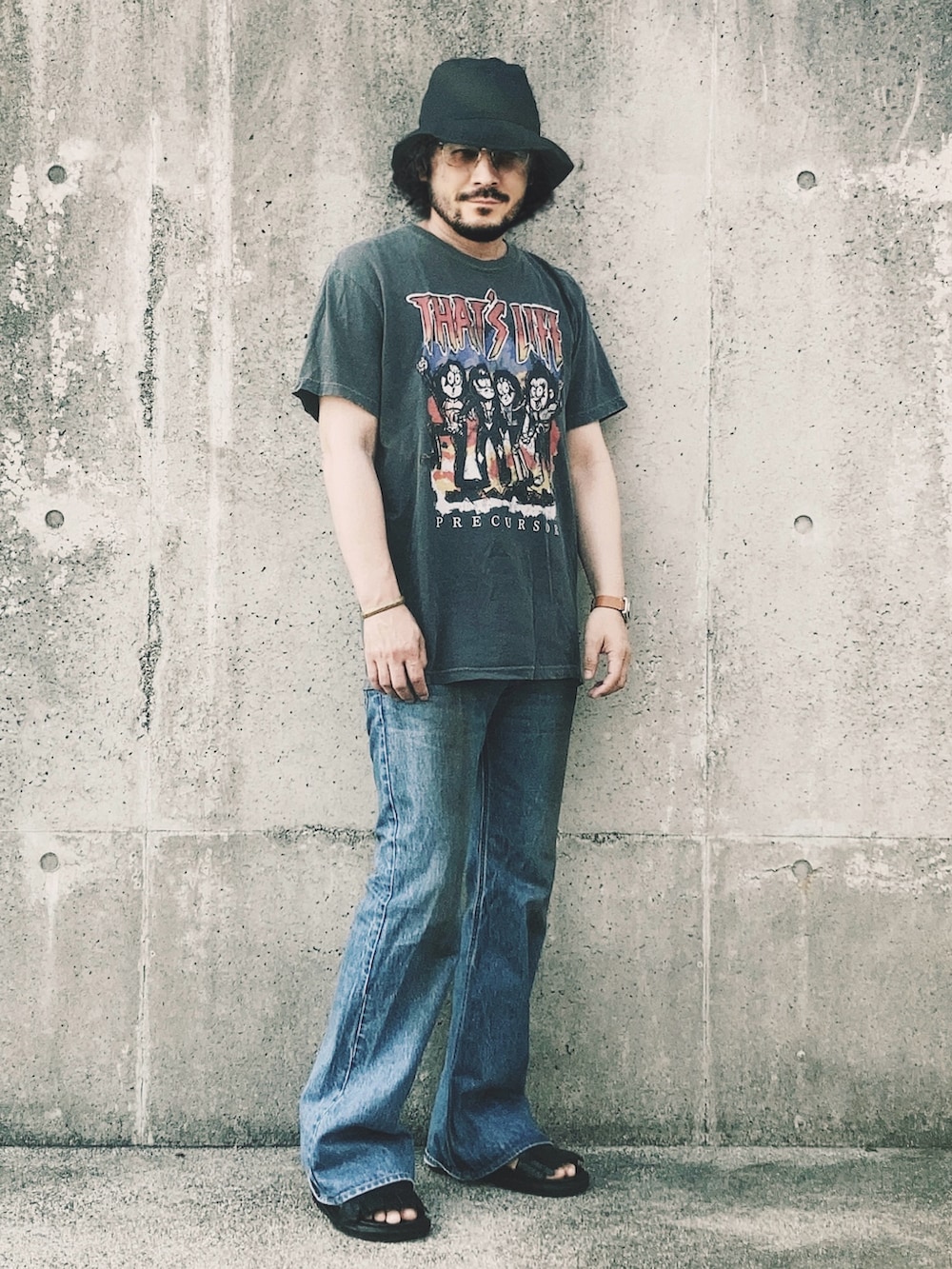 グレー系のTシャツ/カットソー、ブルー系のデニムパンツ、ブラック系のサンダルを着用したメンズの夏コーディネートの2枚目の写真