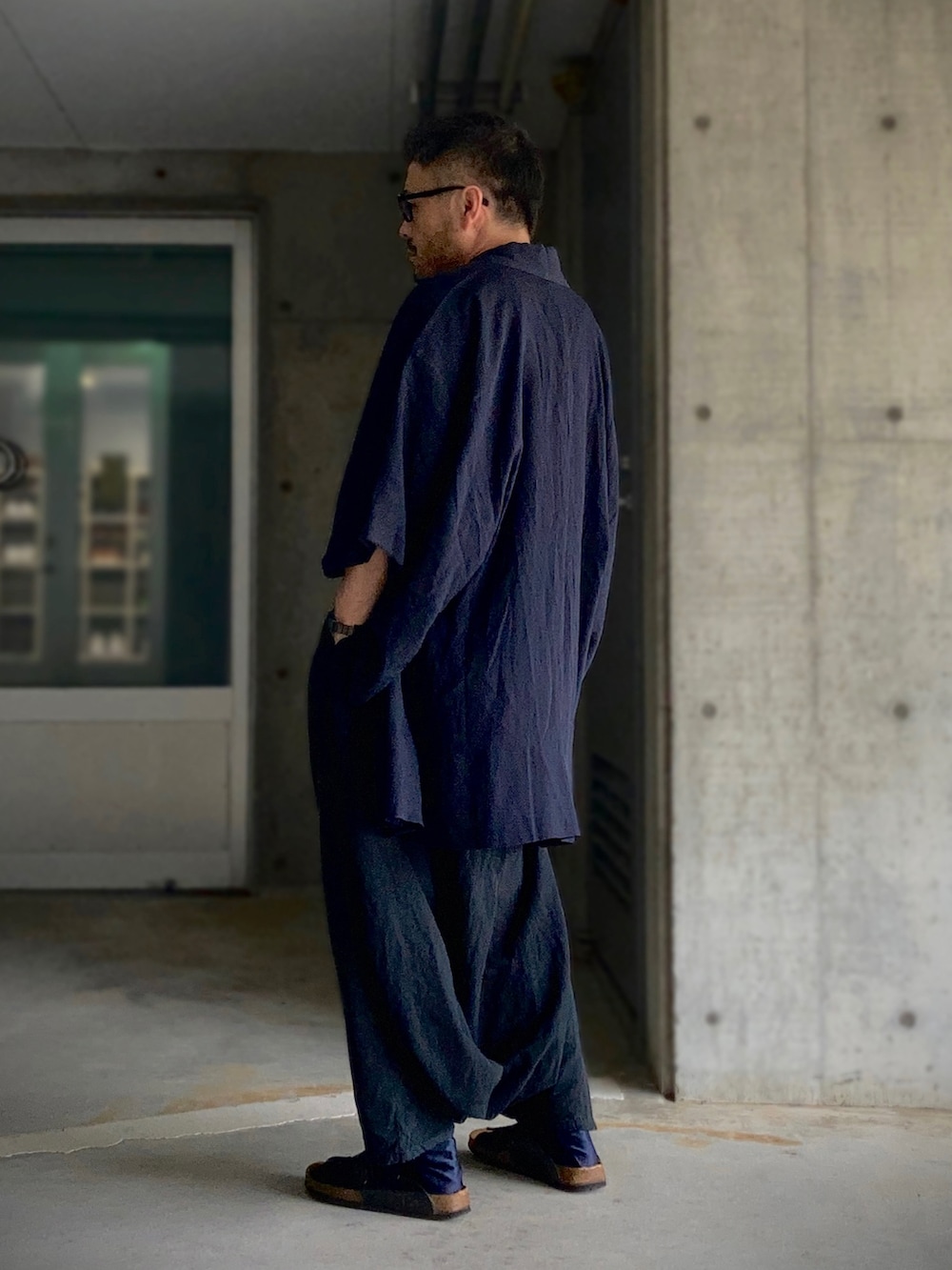 ブラウン系のタンクトップ、ホワイト系のタンクトップ、ブラック系のその他パンツを着用したメンズの夏コーディネートの4枚目の写真