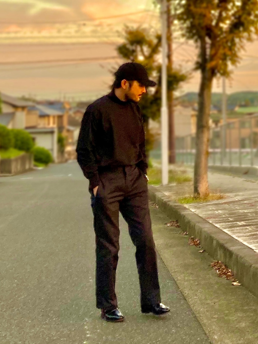 ブラック系のTシャツ/カットソー、ブルー系のチノパンツ、ブラック系のドレスシューズを着用したメンズの秋コーディネートの2枚目の写真