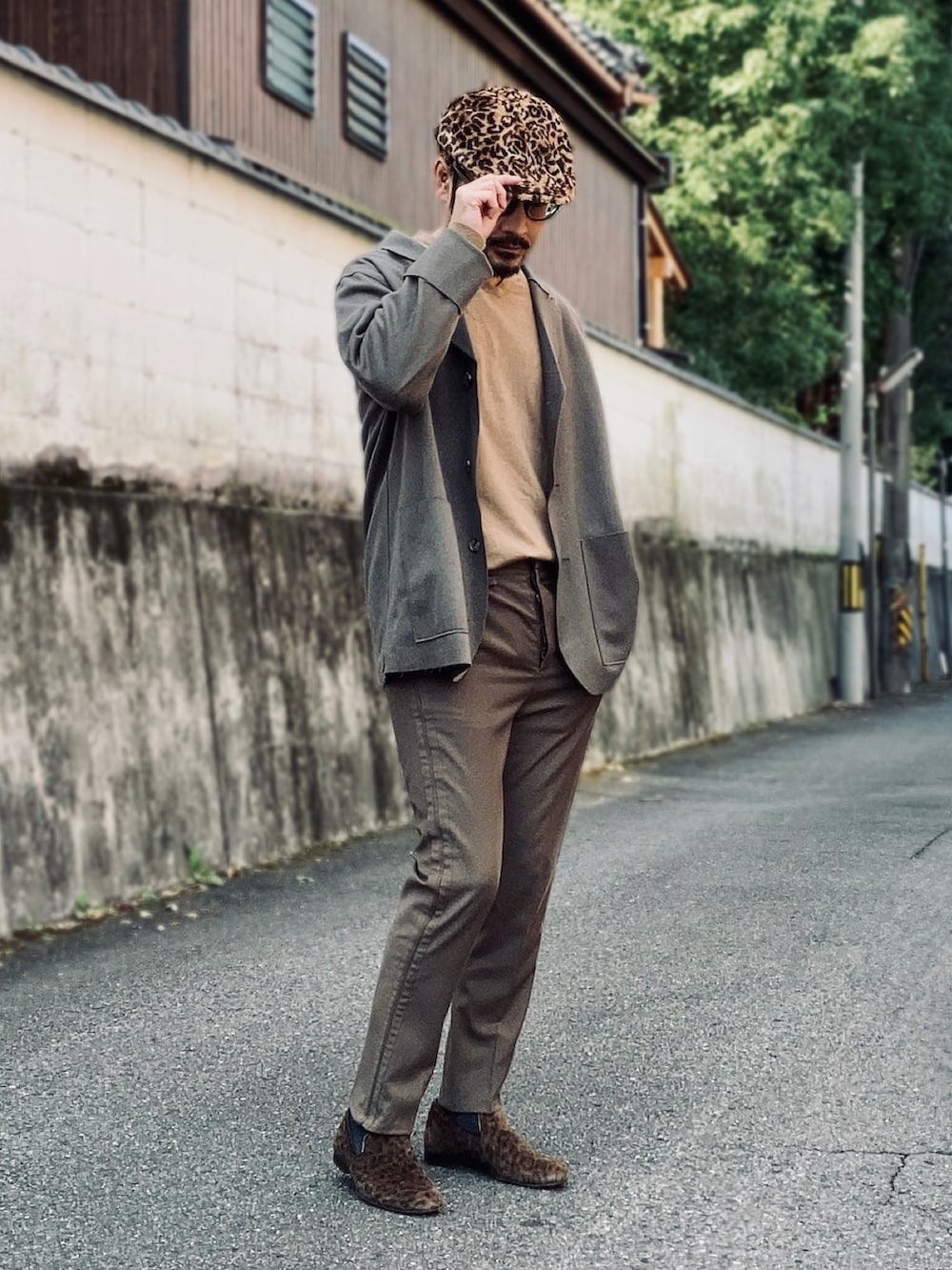 ブラウン系のニット/セーター、ブラウン系のテーラードジャケット、グリーン系のスラックスを着用したメンズの秋コーディネートの3枚目の写真