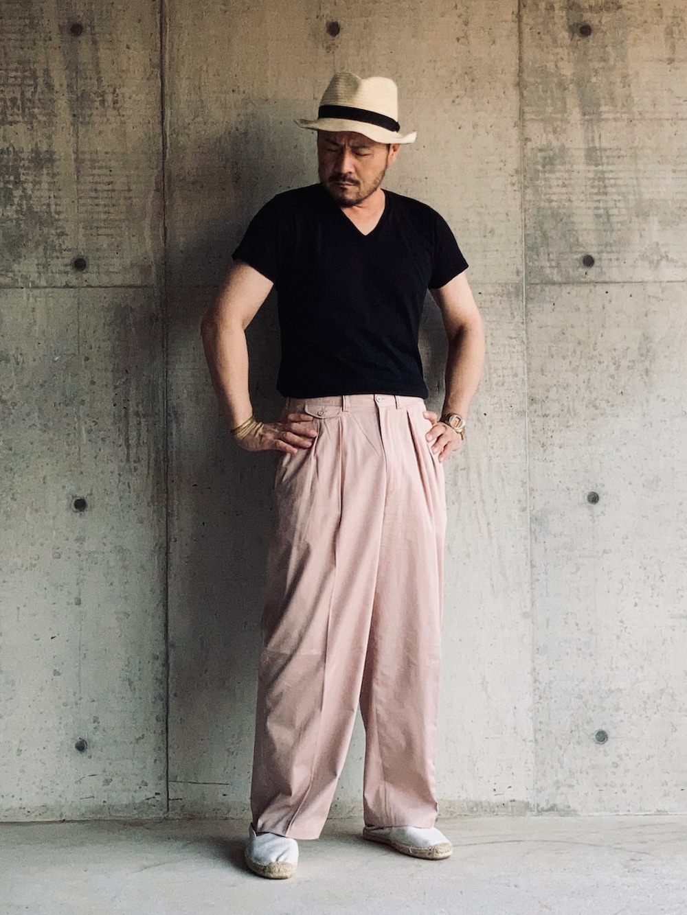 ブラック系のTシャツ/カットソー、ピンク系のスラックス、ホワイト系のスリッポンを着用したメンズの夏コーディネートの2枚目の写真