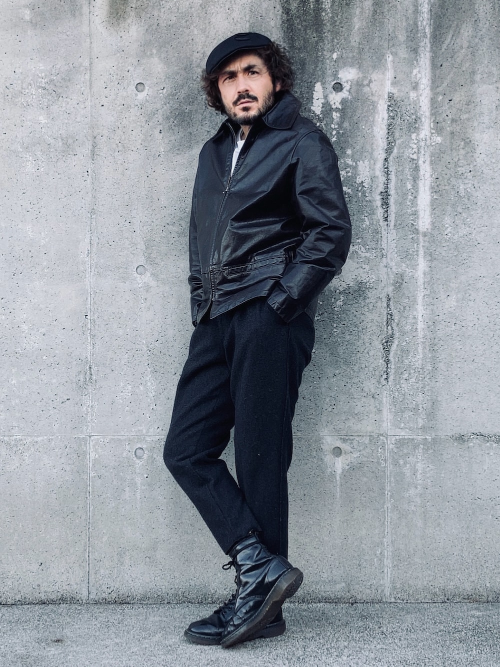 ホワイト系のTシャツ/カットソー、ブラック系のライダースジャケット、ブラック系のスラックスを着用したメンズの冬コーディネートの3枚目の写真