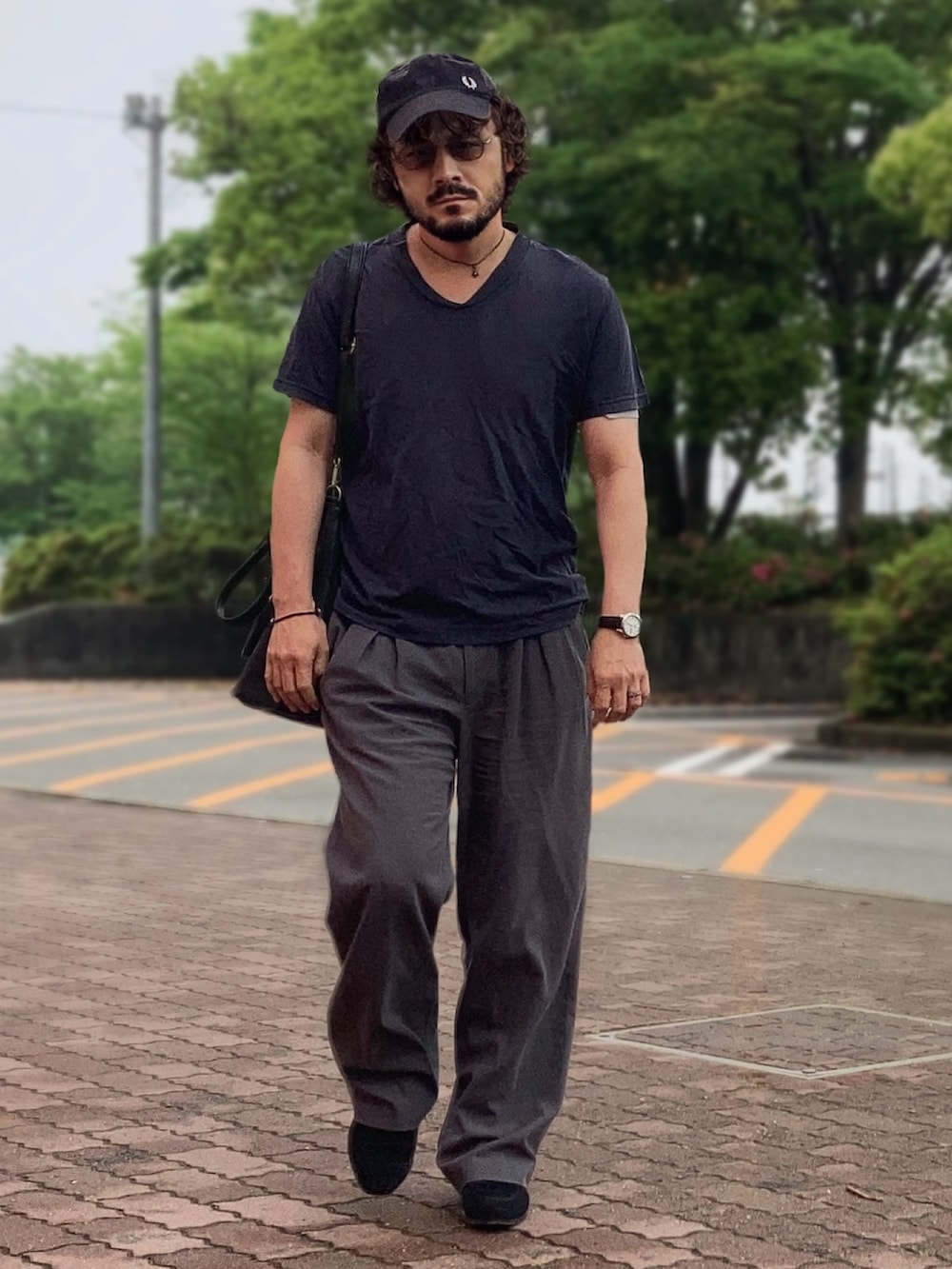 グレー系のTシャツ/カットソー、グレー系のスラックス、ブラック系のローファーを着用したメンズの春コーディネートの2枚目の写真