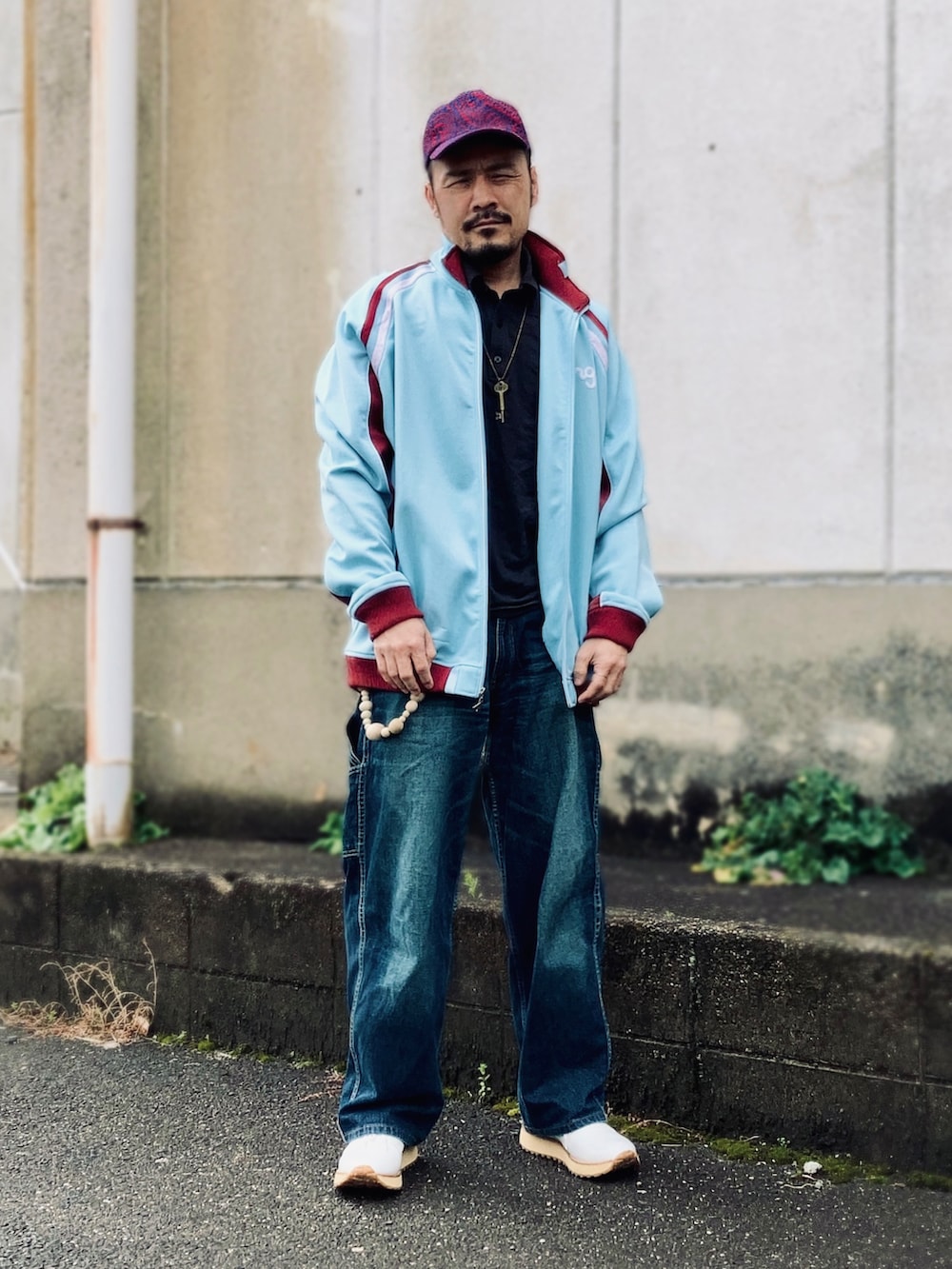 ブラック系のポロシャツ、ブルー系のその他アウター、ブルー系のデニムパンツを着用したメンズの春コーディネートの4枚目の写真