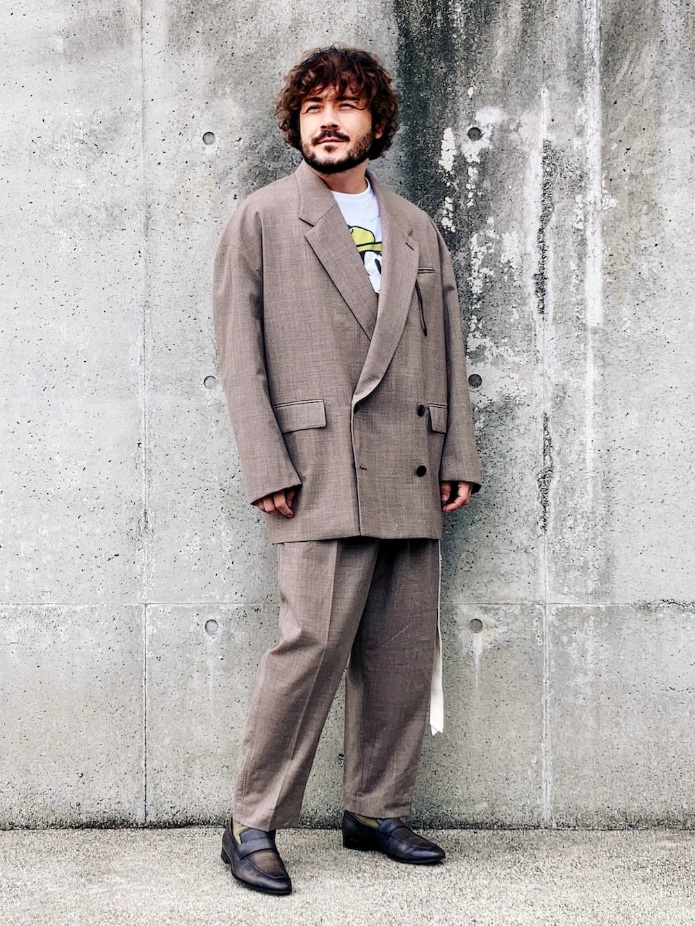 ホワイト系のTシャツ/カットソー、ブラウン系のテーラードジャケット、ブラウン系のスラックスを着用したメンズの秋コーディネートの3枚目の写真