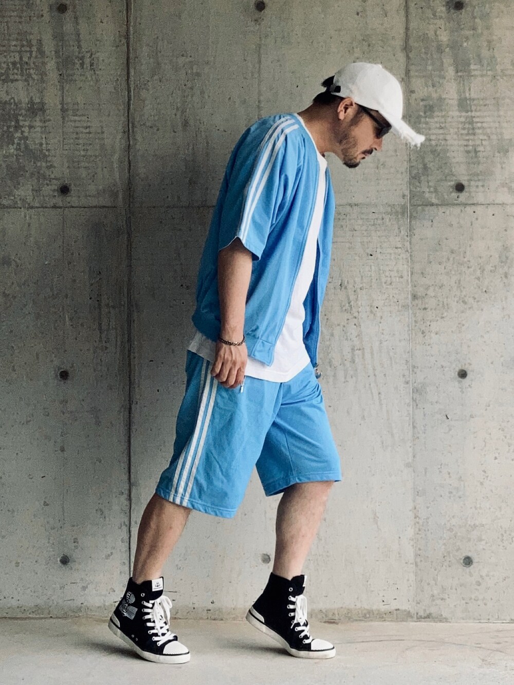 ブルー系のセットアップ、ホワイト系のTシャツ/カットソー、ブラック系のスニーカーを着用したメンズの夏コーディネートの2枚目の写真