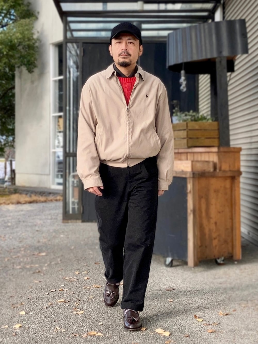 ブラック系のポロシャツ、レッド系のニット/セーター、ベージュ系のブルゾンを着用したメンズの冬コーディネートの3枚目の写真