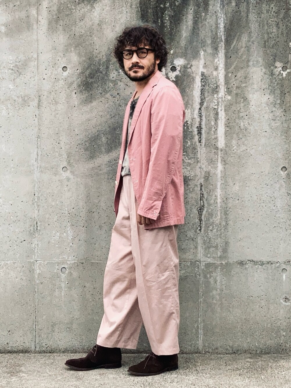 ブラウン系のTシャツ/カットソー、ピンク系のテーラードジャケット、ピンク系のスラックスを着用したメンズの秋コーディネートの3枚目の写真