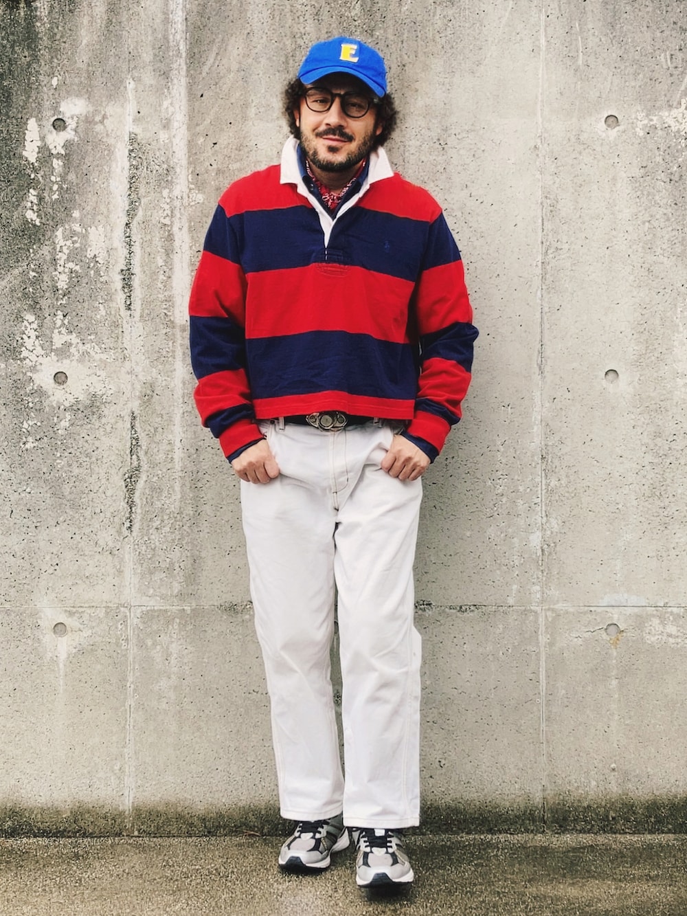 レッド系のポロシャツ、ホワイト系のデニムパンツ、ブラック系のスニーカーを着用したメンズの冬コーディネートの3枚目の写真