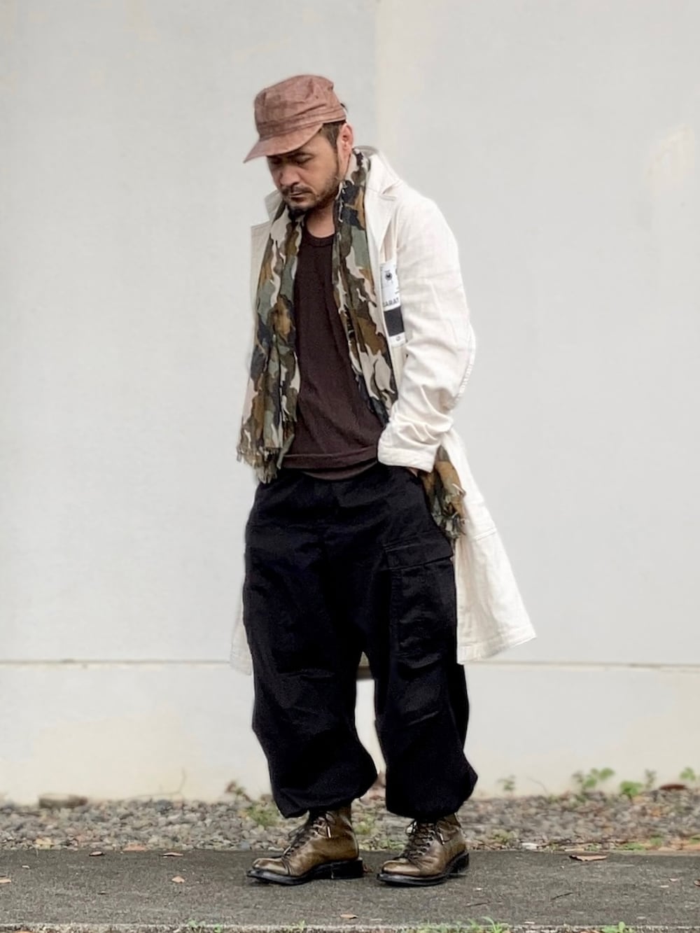 ブラウン系のタンクトップ、ホワイト系のダウンジャケット/コート、ブラック系のカーゴパンツを着用したメンズの秋コーディネートの2枚目の写真