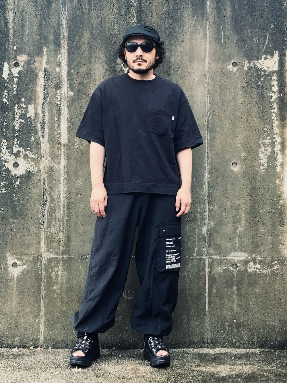 ブラック系のパンツ、ブラック系のサンダル、ブラック系のTシャツ/カットソーを着用したメンズの夏コーディネートの2枚目の写真