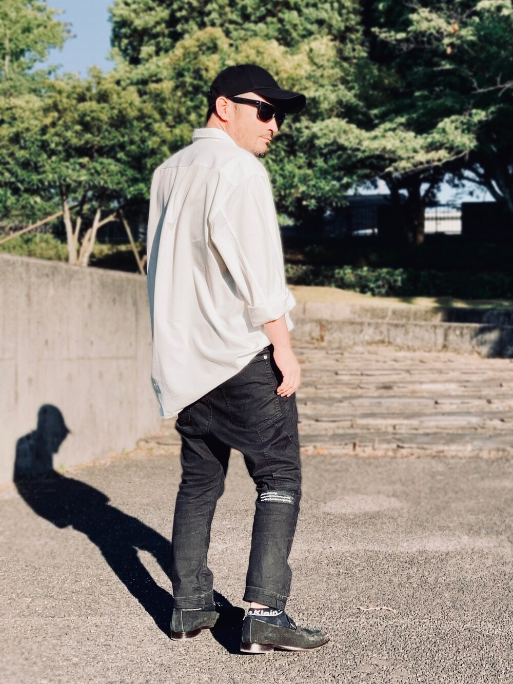 ホワイト系のシャツ/ブラウス、ブラック系のデニムパンツ、ブラック系のローファーを着用したメンズの夏コーディネートの4枚目の写真