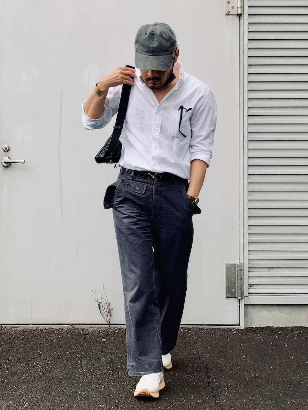 ホワイト系のシャツ/ブラウス、グレー系のスラックス、ホワイト系のスニーカーを着用したメンズの夏コーディネートの2枚目の写真