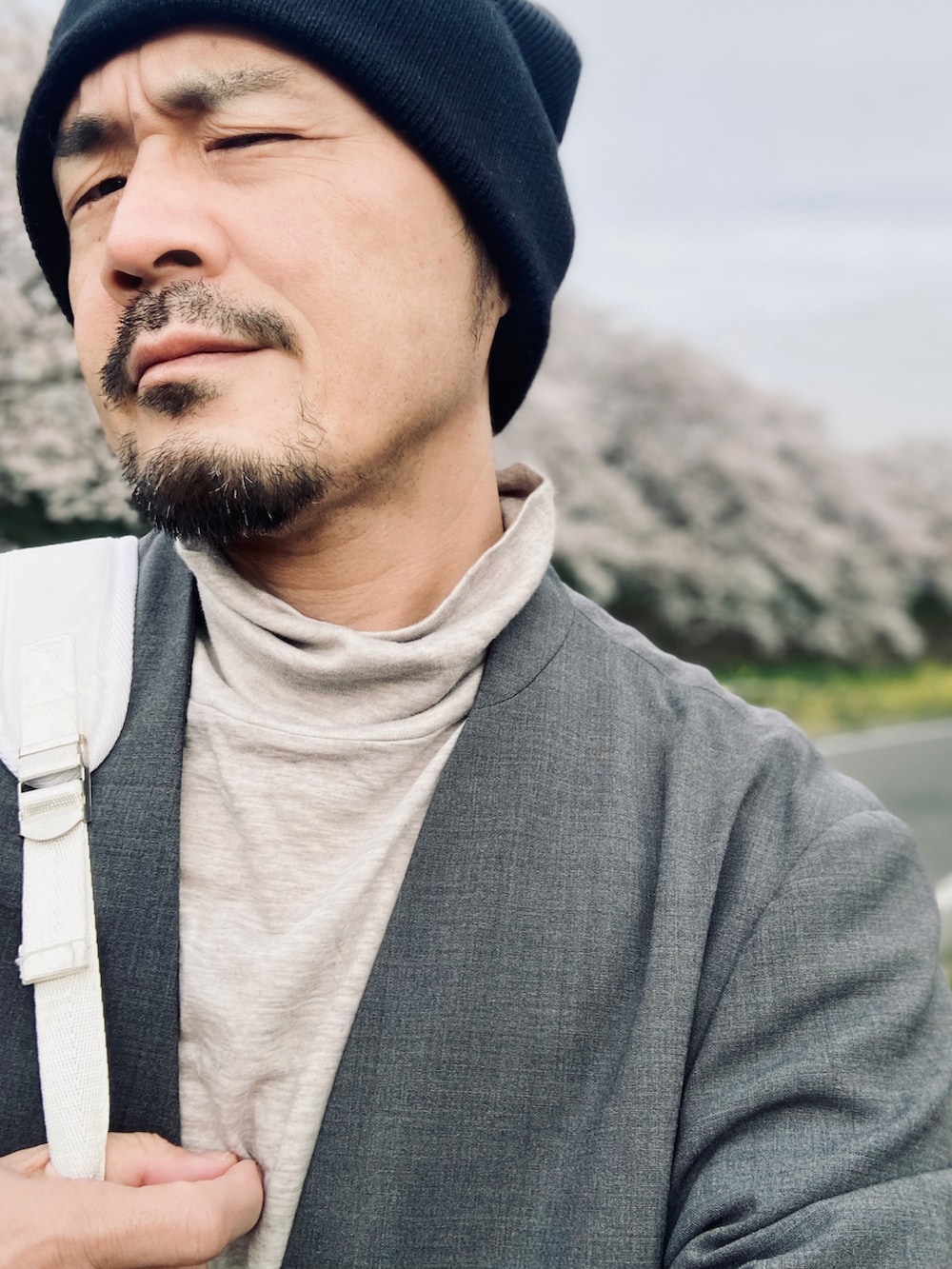 グレー系のTシャツ/カットソー、グレー系のテーラードジャケット、ホワイト系のデニムパンツを着用したメンズの春コーディネートの5枚目の写真