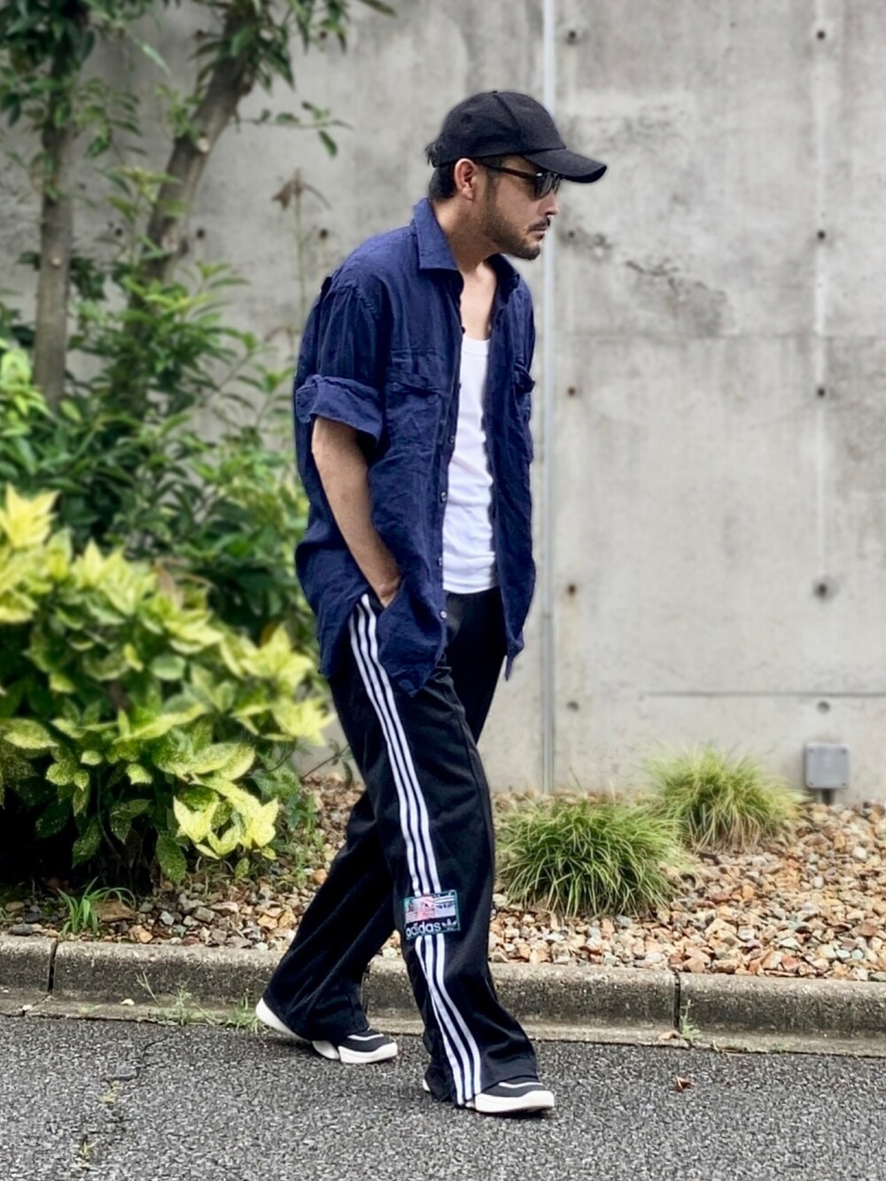 ホワイト系のタンクトップ、ブルー系のシャツ/ブラウス、ブラック系のスウェットパンツを着用したメンズの夏コーディネートの2枚目の写真