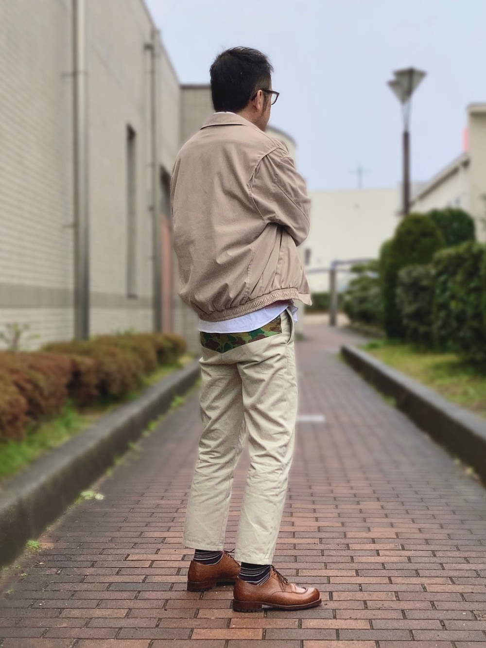 ピンク系のニット/セーター、ベージュ系のブルゾン、ホワイト系のシャツ/ブラウスを着用したメンズの春コーディネートの2枚目の写真