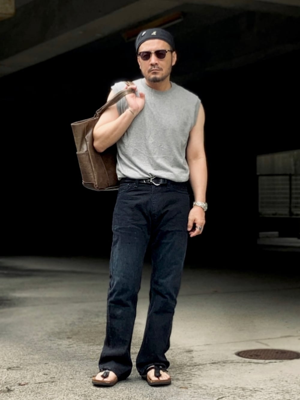 グレー系のTシャツ/カットソー、ブラック系のデニムパンツ、ブラック系のサンダルを着用したメンズの夏コーディネートの4枚目の写真