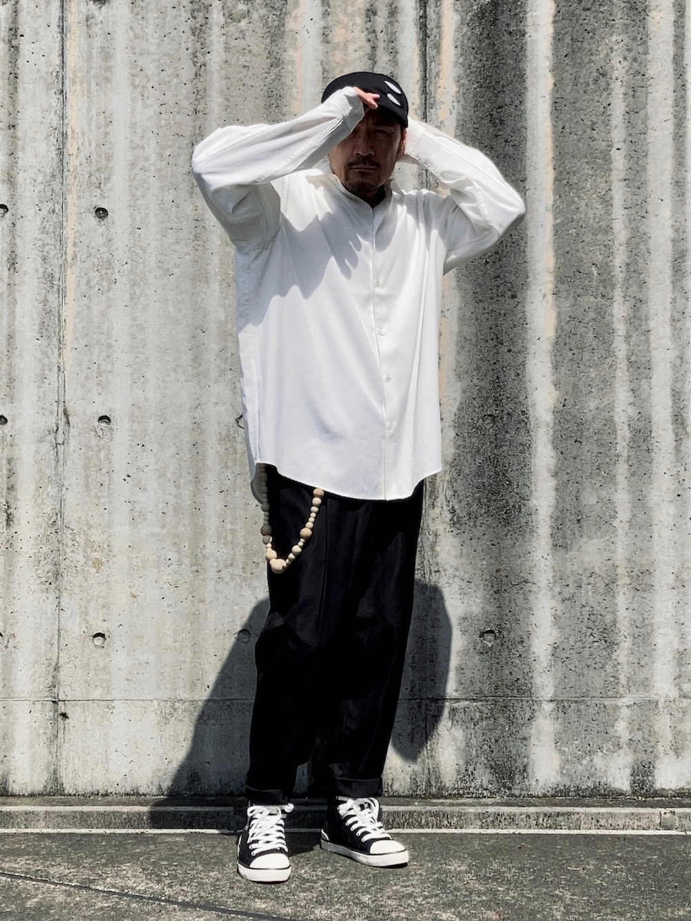 ホワイト系のシャツ/ブラウス、ブラック系のスラックス、ブラック系のスニーカーを着用したメンズの春コーディネートの3枚目の写真