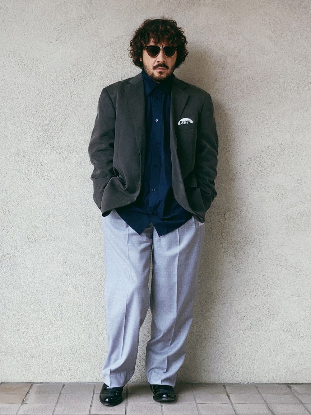 ブラック系のシャツ/ブラウス、グレー系のテーラードジャケット、グレー系のスラックスを着用したメンズの秋コーディネートの2枚目の写真